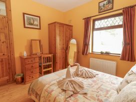 A bedroom with a bed and furniture at Coole Gate Lodge in Gort, County Galway
