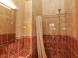A shower area with a curtain and mirror at Coole Gate Lodge, Gort, County Galway