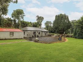 A house with trees and a patio at Coole Gate Lodge, Gort, County Galway