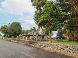 A house with stone walls and trees on the exterior at Coole Gate Lodge in Gort, County Galway