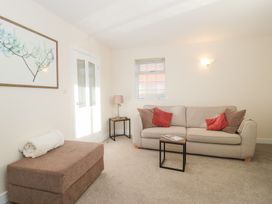 A living room with a sofa and coffee table at Wellinghill Cottage at Wellinghill House Charlton Kings