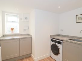 A laundry room with a washing machine and sink at Wellinghill Cottage at Wellinghill House Charlton Kings