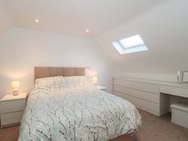 A bedroom with a bed and bedside tables at Wellinghill Cottage at Wellinghill House Charlton Kings