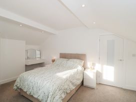 A bedroom with a bed and bedside table at Wellinghill Cottage at Wellinghill House Charlton Kings