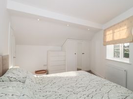 A bedroom with a bed and wardrobe at Wellinghill Cottage at Wellinghill House, Charlton Kings