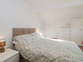 A bedroom with a bed and wardrobe at Wellinghill Cottage at Wellinghill House, Charlton Kings