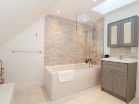 A bathroom with a shower and bathtub at Wellinghill Cottage at Wellinghill House, Charlton Kings
