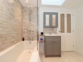 A bathroom with a bathtub and sink at Wellinghill Cottage at Wellinghill House Charlton Kings