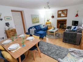 A living room with a dining table and chairs at Tawe Cottage in Swansea