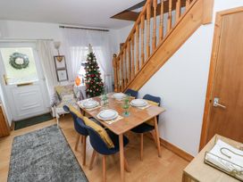 A dining room with a table set and a Christmas tree at Tawe Cottage Swansea