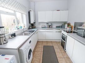 A kitchen with appliances and cabinets at Tawe Cottage in Swansea