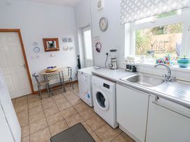 A kitchen with a washing machine and table at Tawe Cottage in Swansea
