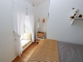 A bedroom with a bed and window seating at Tawe Cottage Swansea