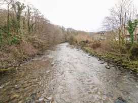 A river surrounded by trees and rocks near houses at Tawe Cottage Swansea
