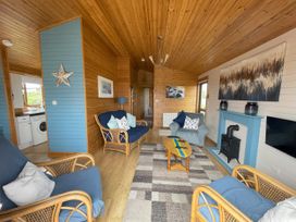 A living room with a sofa and armchairs in Lamorna Sennen