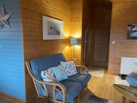 A living room with a sofa and wall art at Lamorna in Sennen