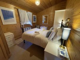 A bedroom with a bed and nightstand at Lamorna Sennen