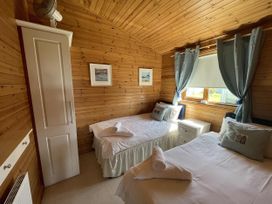 A bedroom with two beds and a wardrobe at Lamorna Sennen