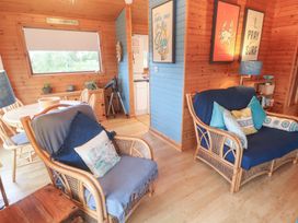 A living room with sofas and a dining area at Lamorna in Sennen