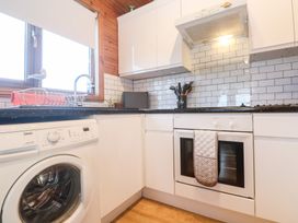 A kitchen with a washing machine and oven at Lamorna in Sennen