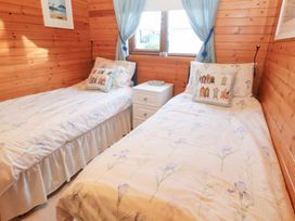 A bedroom with two beds and a bedside table at Lamorna Sennen