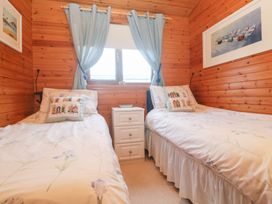 A bedroom with two single beds and a nightstand at Lamorna Sennen