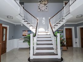 A hallway with a staircase and a clock at Woodlawn Retreat in Portanure near Lough Gowna