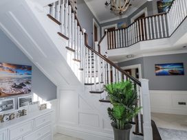A hallway with a staircase and decorative pictures at Woodlawn Retreat in Portanure near Lough Gowna