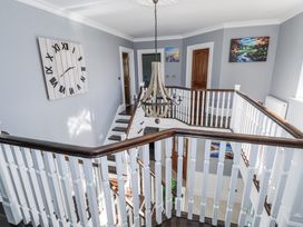 A hallway with a clock and chandelier at Woodlawn Retreat Portanure near Lough Gowna