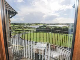 A view of a grassy area and a lake from a balcony at Woodlawn Retreat in Portanure near Lough Gowna