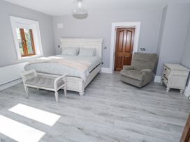 A bedroom with a bed and armchair at Woodlawn Retreat in Portanure near Lough Gowna