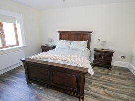 A bedroom with a bed and nightstands at Woodlawn Retreat in Portanure near Lough Gowna