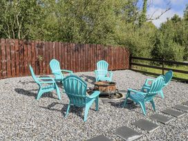 A garden with adirondack chairs and a fire pit at Woodlawn Retreat Portanure near Lough Gowna