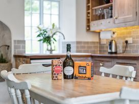 A kitchen with a table displaying a bottle, ginger cookies, and tea at Treovis Cottage in Callington