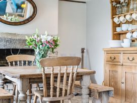 A dining room with a table, chairs, and a flower vase at Treovis Cottage in Callington
