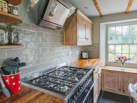 A kitchen with a gas stove and cabinets at Treovis Cottage in Callington