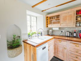 A kitchen with wooden cabinets and a sink at Treovis Cottage in Callington