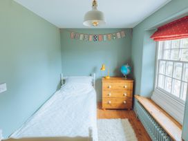 A bedroom with a bed and dresser at Treovis Cottage Callington
