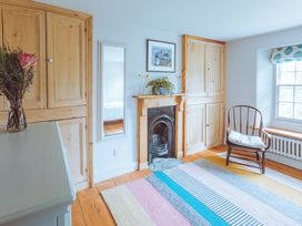 A living room with a flower vase and a fireplace at Treovis Cottage in Callington