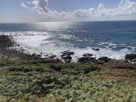 An ocean view with rocks and vegetation near the shore at Treovis Cottage Callington