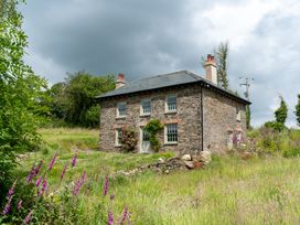 A stone house with windows and chimney at Treovis Cottage in Callington