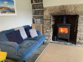 A living room with a sofa and a fireplace at Treovis Cottage in Luckett near Kelly Bray