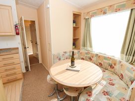 A dining area with a round table and seating at Number 38 Chichester