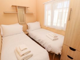 A bedroom with two beds and a mirrored shelf at Number 38 Chichester