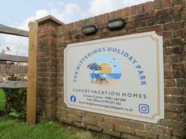 A sign for The Witterings Holiday Park with contact details and logo at Number 38 Chichester