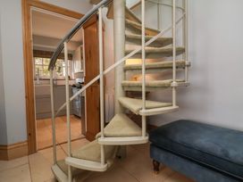 A spiral staircase with a sofa at Rookery Cottage in Lynton