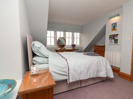 A bedroom with a bed, bedside table and mirror at Rookery Cottage in Lynton
