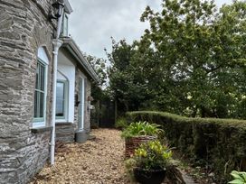 An outdoor pathway with plants and a stone wall at Rookery Cottage in Lynton