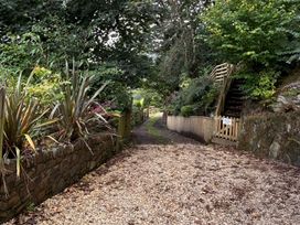 A pathway surrounded by plants and trees at Rookery Cottage in Lynton
