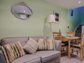 A living room with a sofa and dining table at Cherry Pip in Charmouth